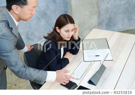 A woman communicating with a male employee with a complicated expression 93253819