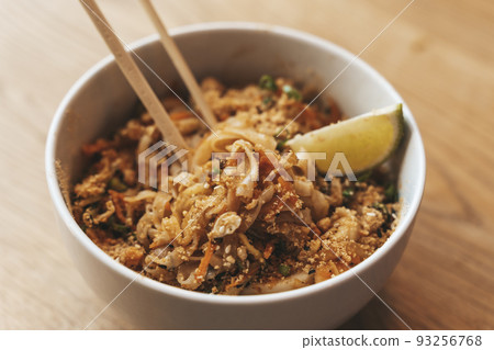 Thai noodle Pad Thai bowl background. Traditional rice noodles with shrimp and seafood. Asian food concept. Thai noodle Pad Thai bowl background. Traditional rice noodles with shrimp and seafood. Asian food concept. 93256768