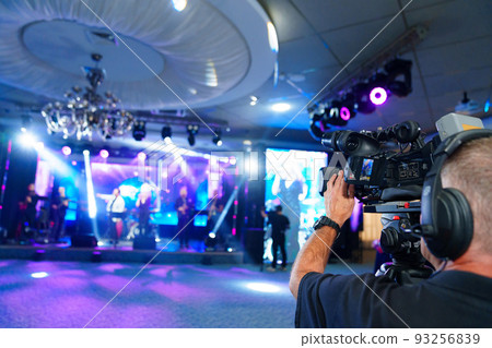 videographer with broadcast video camera to show on large screens. videographer with broadcast video camera to show on large screens. 93256839