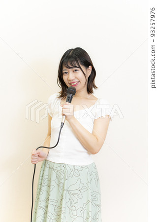 穿著夏裝的可愛女人拿著麥克風 93257976