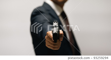 A person in a suit holding a pistol 93259294