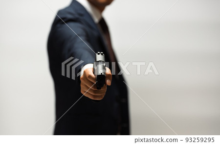 A person in a suit holding a pistol A person in a suit holding a pistol 93259295
