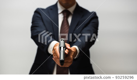 A person in a suit holding a pistol A person in a suit holding a pistol 93259296