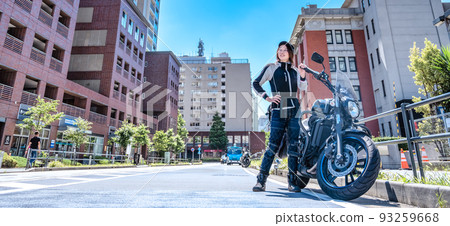 A female rider touring Yokohama on a large American motorcycle 93259668