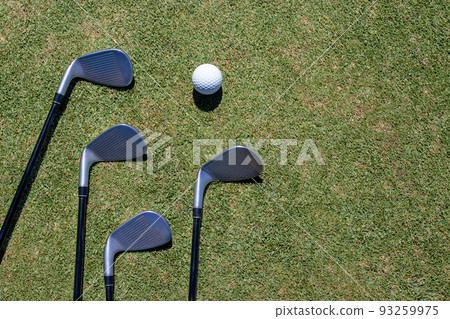 Golf club and golf ball on green grass Golf club and golf ball on green grass 93259975