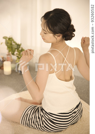 Back view of a young woman doing skin care 93260582