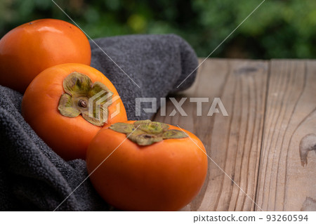 一張柿子在木板上和一條灰色毛巾的照片 一張柿子在木板上和一條灰色毛巾的照片 93260594