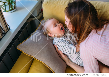 Mom plays at home with a small child on the couch, have fun. 93261382