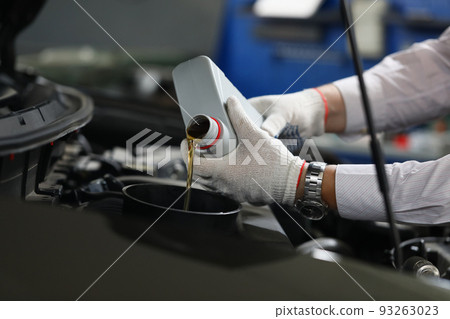 Mechanical filling of oil into car in repair garage Mechanical filling of oil into car in repair garage 93263023