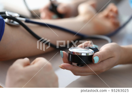 Female doctor hands male patient blood pressure measurement 93263025