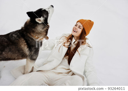 portrait of a woman in the snow playing with a dog fun friendship fresh air 93264011