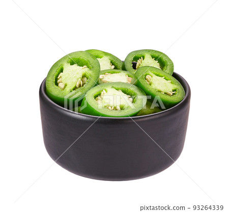 Fresh green cut chili pepper pieces in a black ceramic bowl isolated on white background. 93264339