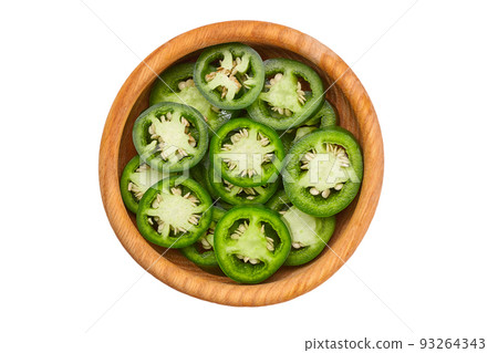 Fresh green cut chili pepper pieces in a wooden bowl isolated on white background top view. 93264343