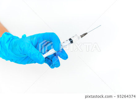 women's hands in blue gloves with a disposable syringe.  93264374