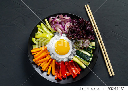 Close-up of a Korean dish, with a variety of appetizers with vegetables and eggs. Diet. pibimpap. Top view. Round plate. Close-up of a Korean dish, with a variety of appetizers with vegetables and eggs. Diet. pibimpap. Top view. Round plate. 93264481