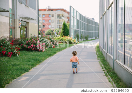 Adorable little 1-2 year old toddler boy walking along the street in Cracow, Poland Adorable little 1-2 year old toddler boy walking along the street in Cracow, Poland 93264690