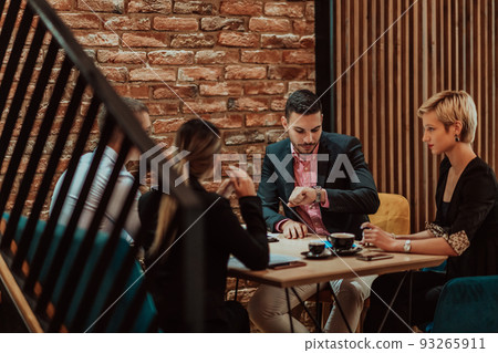 Happy businesspeople smiling cheerfully during a meeting in a coffee shop. Group of successful business professionals working as a team in a multicultural workplace. Happy businesspeople smiling cheerfully during a meeting in a coffee shop. Group of successful business professionals working as a team in a multicultural workplace. 93265911