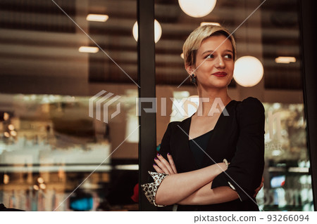 Business woman in a black suit, successful confidence with arms crossed in modern office. Selective focus Business woman in a black suit, successful confidence with arms crossed in modern office. Selective focus 93266094