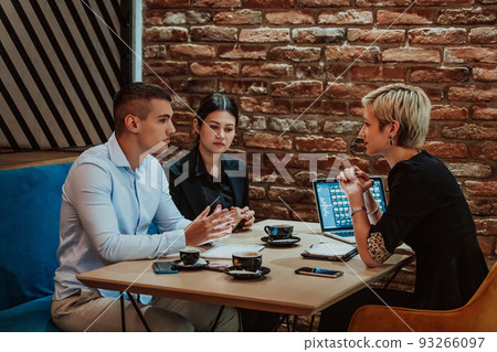 Happy businesspeople smiling cheerfully during a meeting in a coffee shop. Group of successful business professionals working as a team in a multicultural workplace. 93266097