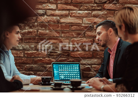 Happy businesspeople smiling cheerfully during a meeting in a coffee shop. Group of successful business professionals working as a team in a multicultural workplace. 93266312