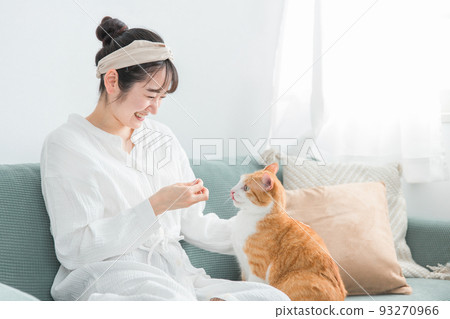 Japanese woman giving a snack to a cat (food) 93270966