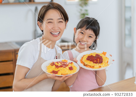 小學生和媽媽在廚房裡用完成的煎蛋捲飯微笑 93272833