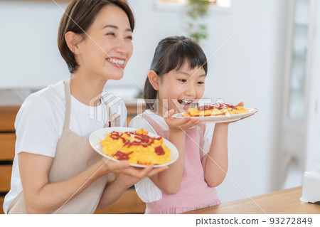 小學生和媽媽在廚房裡用完成的煎蛋捲飯微笑 93272849