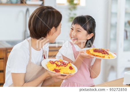 小學生和媽媽在廚房裡用完成的煎蛋捲飯微笑 93272850