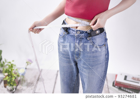 Young woman measuring waist Young woman measuring waist 93274681