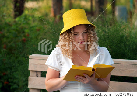 Girl with book outdoors 93275085