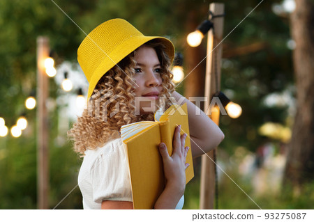 Girl with book outdoors 93275087