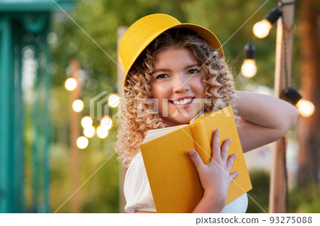 Girl with book outdoors 93275088