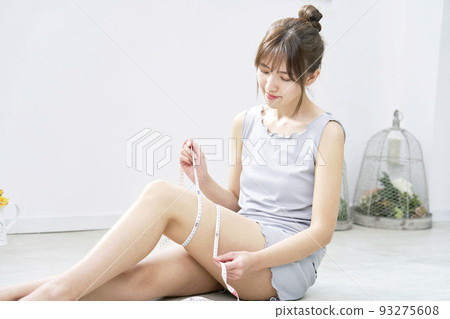 在家用捲尺測量大腿的女人 93275608