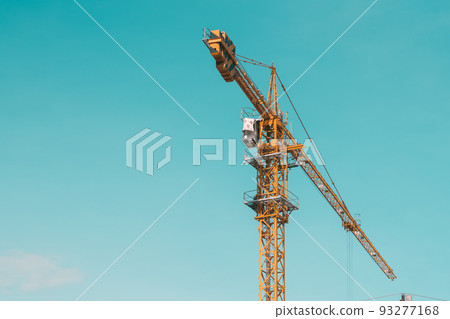 Tower Crane lattice boom hook clear blue sky sun background. Construction site work building installation Tower Crane lattice boom hook clear blue sky sun background. Construction site work building installation 93277168