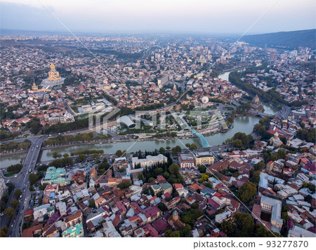 Drone view of old city located near hills and river on summer day in Tbilisi, Georgia 93277870