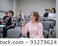 College students listen attentively to the professors lecture, sitting on chairs in a large audience 93278624