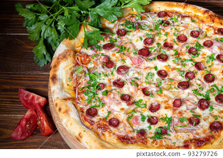 Pizza with bacon and cheese, herbs and cherry tomatoes. With mozzarella, shrimp and octopus, mussels and other products on a wooden background. Pizza with bacon and cheese, herbs and cherry tomatoes. With mozzarella, shrimp and octopus, mussels and other products on a wooden background. 93279726