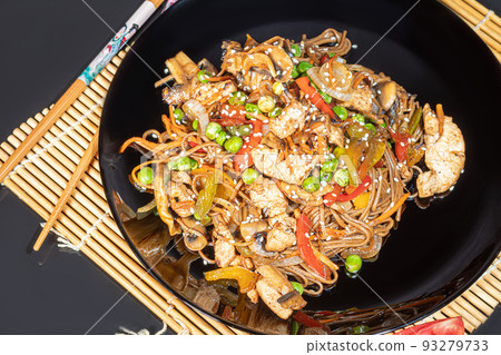 Udon noodles with meat, mushrooms and vegetables. Sprinkled with sesame seeds. Asian food, roast on black background, 93279733