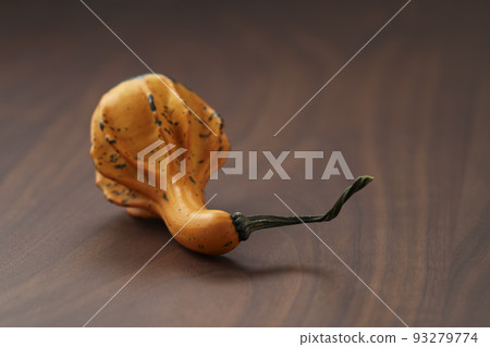 Decorative pear pumpkin on wood table 93279774