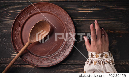 Ukrainian woman sitting in national restaurant and waiting for order. Girl knocks fingers nervously 93280459