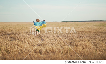 Happy little boy - Ukrainian patriot child running with national flag in field after collection Happy little boy - Ukrainian patriot child running with national flag in field after collection 93280476