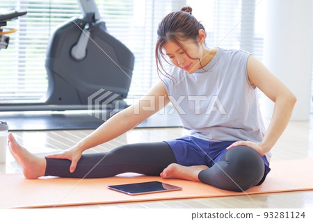 Woman exercising while looking at tablet monitor 93281124