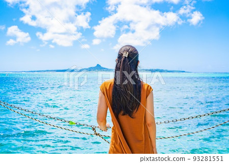 A woman staring at a distant island by the sea Summer vacation A woman staring at a distant island by the sea Summer vacation 93281551