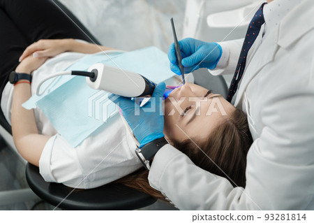 Closeup of female patient in dental chair on a procedure of intraoral digital scan of her teeth 93281814