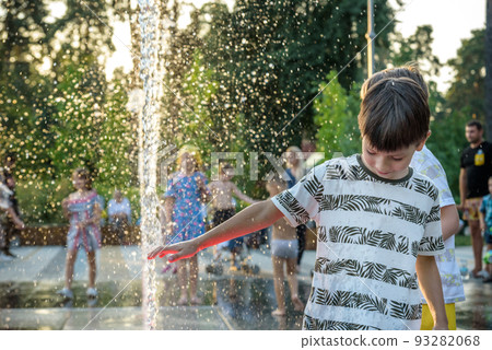 Boys jumping in water fountains. Children playing with a city fountain on hot summer day. Happy friends having fun in fountain. Summer weather. Friendship, lifestyle and vacation Boys jumping in water fountains. Children playing with a city fountain on hot summer day. Happy friends having fun in fountain. Summer weather. Friendship, lifestyle and vacation 93282068