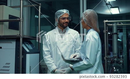 Two scientist in professional uniform working in laboratory Two scientist in professional uniform working in laboratory 93282393
