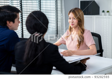 Young female asian candidate tries to impress interviewer by being competent. Young female asian candidate tries to impress interviewer by being competent. 93282593
