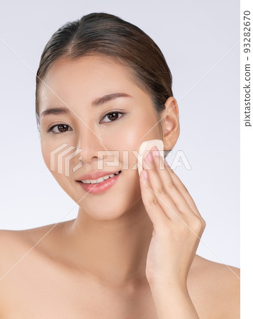 Gorgeous woman applying her cheek with dry powder. Gorgeous woman applying her cheek with dry powder. 93282670