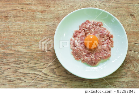 raw mashed pork ingredient food tooping eggg yolk on plate raw mashed pork ingredient food tooping eggg yolk on plate 93282845