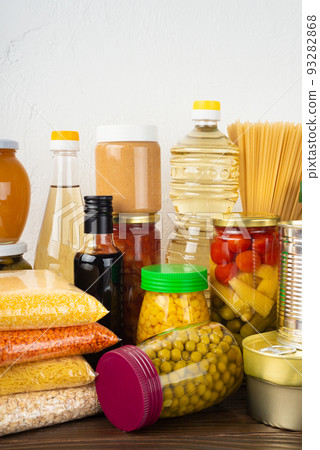 Emergency survival food set on dark wooden kitchen table 93282868